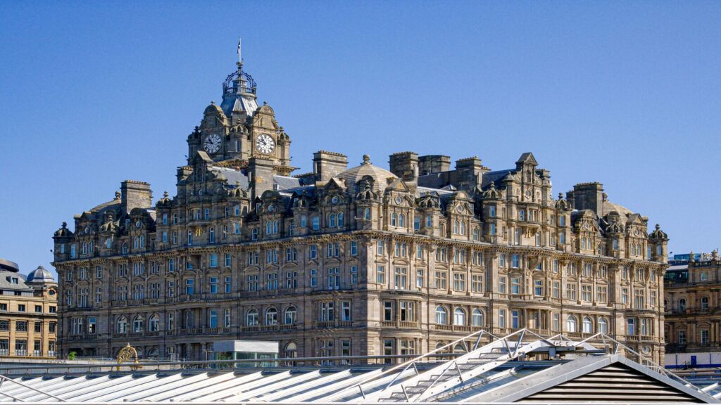 Exterior view of The Balmoral Hotel Edinburgh showing its historic sandstone facade and iconic 190 foot clock tower on Princes Street.