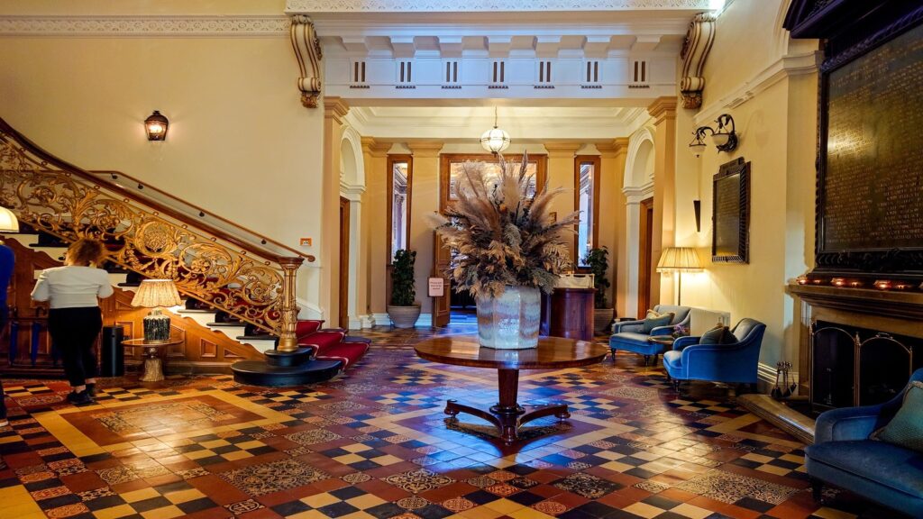 The stylishly designed reception lobby of Gleneagles Townhouse in Edinburgh, showcasing colorful plush seating, modern art, and historic architecture.